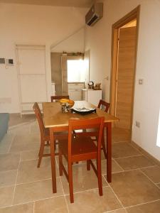 孔韦尔萨诺Adalù apartments的一间厨房,内设一张木桌和椅子