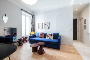 尼斯Au Coeur de La Libé的客厅配有蓝色的沙发和电视