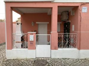TrafariaMaria Trafaria House的粉红色的房子,有门和门