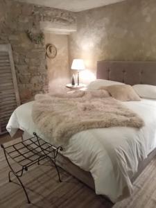 维尔雅尔姆Le Lodge des Flâneurs的一间卧室配有一张大床和毛皮毯子