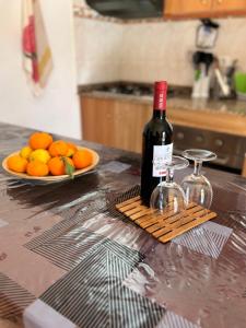 巴尔塞基略Chalet Rutas de Valsequillo的一瓶酒在柜台上,放上一盘橘子