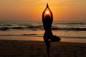 阿维拉纳海滩Villas VR Beachwalk Avellanas的日落时在海滩上做瑜伽的女人
