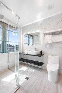 布鲁克林Liberty View Brooklyn Hotel的一间带玻璃淋浴和卫生间的浴室