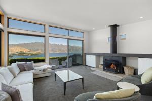 皇后镇Whakata on Whitbourn - Luxury Retreat With Spa的带沙发和壁炉的客厅