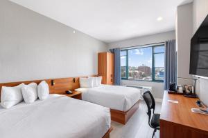 布鲁克林Liberty View Brooklyn Hotel的酒店客房设有两张床和一台平面电视。