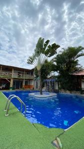 蒙塔尼塔HOSTAL SINAGOGA的一座蓝色的游泳池,在一座建筑前有棕榈树