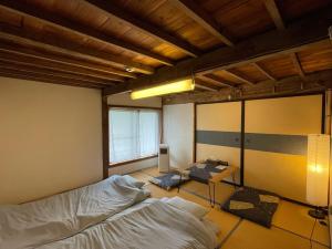 山梨市MEKIKI古民家的一间设有两张床和一张桌子的房间