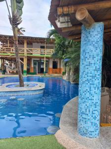 蒙塔尼塔HOSTAL SINAGOGA的度假村的游泳池,设有蓝色瓷砖柱