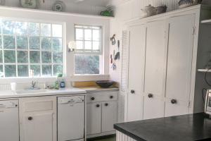 Cherry GroveCherry Grove Enchantment的厨房配有白色橱柜和水槽