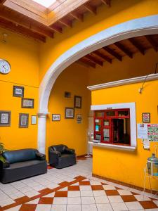 杜兰戈Hotel Buenos Aires的一张黄色的墙壁,在房间里有两个沙发