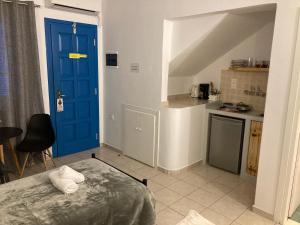 纳克索乔拉艾琳2号公寓式酒店的一间设有蓝色门的房间和一间厨房