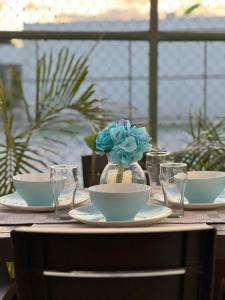 里奥阿托Beach-Style Pool Villa Paradise的一张桌子,上面有盘子和一个花瓶,上面有蓝色的花