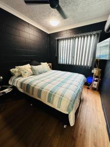 North WardHoliday at Henry St West End, Townsville QLD 3 night min的一间卧室配有一张带铺着地毯的床和窗户。