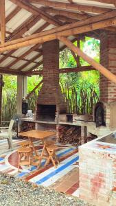 Las TunasNueva Tierra, Ayampe-Suite的庭院设有砖砌壁炉和木桌。
