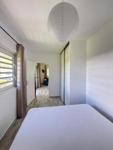 TevaitoaÂpara Feti'a - Mirimiri Lodge的卧室设有一张白色大床和一扇窗户。
