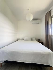 TevaitoaÂpara Feti'a - Mirimiri Lodge的卧室配有白色床罩和白色床罩