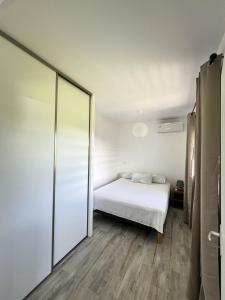 TevaitoaÂpara Feti'a - Mirimiri Lodge的一间卧室设有一张床和一个滑动玻璃门