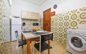 基亚拉蒙泰-古尔菲Gorgeous Apartment In Chiaramonte Gulfi With Kitchen的厨房配有桌子和洗衣机。
