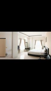 武吉丁宜KHARIZ HOTEL的白色卧室配有床和书桌
