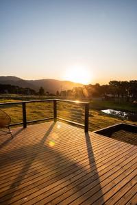 乌鲁比西Linda cabana na Serra catarinense.的享有日落美景的木制甲板