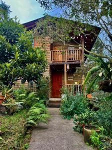 瓜尔内Beehouse Arví Cabaña的房屋设有木门廊和阳台
