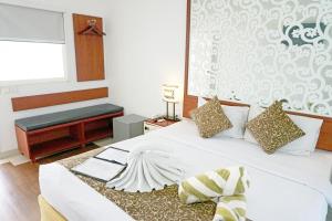 勒吉安轮回客栈的卧室配有白色的床、长凳和窗户。