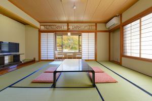 上田市Ooedo Onsen Monogatari Kakeyu的中间设有带玻璃桌的客厅