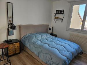 阿卡雄Appartement Arcachon, 2 pièces, 3 personnes - FR-1-319-78的一间卧室配有一张带蓝色毯子的床