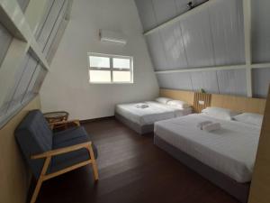 JasinKesang Farm Jasin Melaka by I Housing的一间卧室设有两张床、一把椅子和一个窗户。