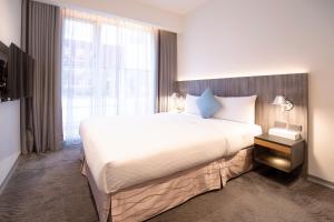 台北丹迪旅店-天津店 的一间卧室设有一张大床和一个大窗户