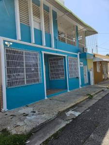 马亚圭斯Newly remodeled 3 BR Center Mayagüez, First Floor Unit1的蓝色的建筑,街道上设有蓝色的门