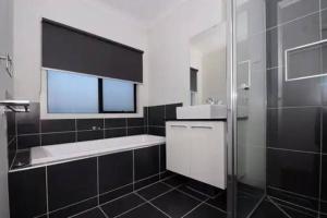 KeysboroughMel south east huge luxury home的黑白浴室设有水槽和淋浴