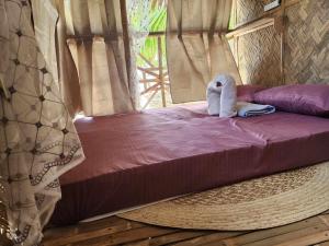 爱妮岛BICE Camp Bucana Beach的床上有一只毛巾动物