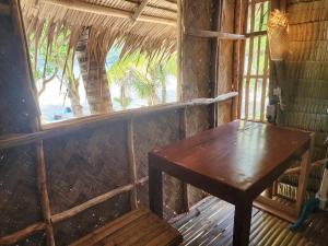 爱妮岛BICE Camp Bucana Beach的窗户客房内的木桌和长凳