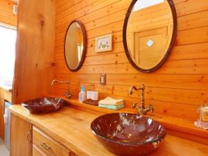 大町市コテージ野の香的浴室设有2个水槽和2面镜子,位于木墙上
