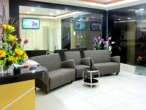 巴力拉惹RG格兰德酒店的一间配有沙发和鲜花的墙上等候室