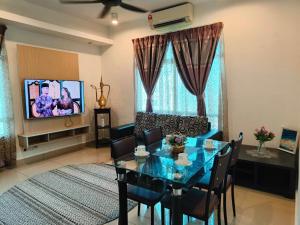 哥打巴鲁HomeStay De’Viana NMS Residence的客厅配有桌子、沙发和电视