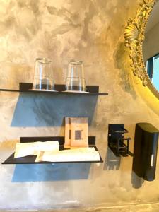 名户Stäy Hotel的墙上一张桌子,上面有两杯玻璃和镜子
