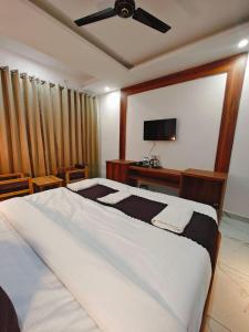 瑞诗凯诗Hotel DC Hills Rishikesh的一间卧室配有一张大床和吊扇