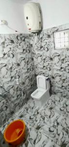 库斯哈尔纳加尔Areca Adventures Family Cottage的浴室拥有黑色和白色的壁纸,设有卫生间