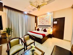 哈里瓦Hotel Rama, Top Rated and Most Awarded Property In Haridwar的酒店客房,配有一张床和两把椅子