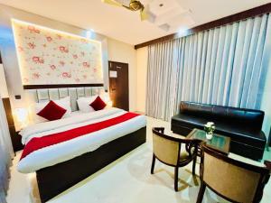 哈里瓦Hotel Rama, Top Rated and Most Awarded Property In Haridwar的一间卧室配有一张床、一张桌子和一张四柱床。