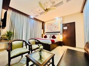哈里瓦Hotel Rama, Top Rated and Most Awarded Property In Haridwar的酒店客房带一张床、一张桌子和椅子