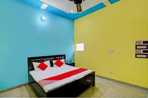 JhājharOYO Flagship Midtown Guesthouse的一间设有床铺的卧室,位于一个拥有绿色墙壁的房间
