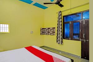 JhājharOYO Flagship Midtown Guesthouse的一间卧室配有一张床和吊扇