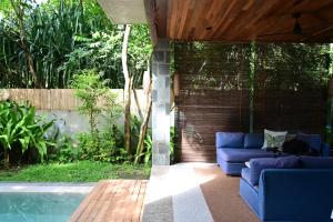 爱妮岛Pandan Villas, El Nido的游泳池旁带蓝色沙发的庭院