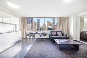 悉尼Oaks Sydney Hyde Park Suites的客厅配有沙发和桌子