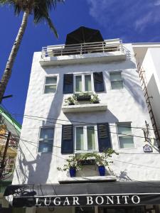 长滩岛好地方住宿加早餐旅馆的一座白色的建筑,里面装有窗户和植物