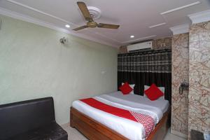 BumlitanOYO A G Residency & Son的一间卧室配有一张带红色枕头的床和吊扇