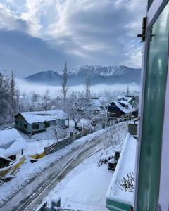古尔马尔格Everest Guest House的从雪覆盖的街道的窗户上可欣赏到风景